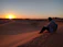 Smiling traveler enjoying a sunset view over the Sahara dunes.