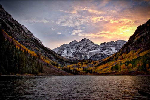 body of water across the mountain during sunset