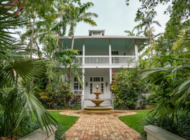 white house with outdoor fountain and plush landscaping