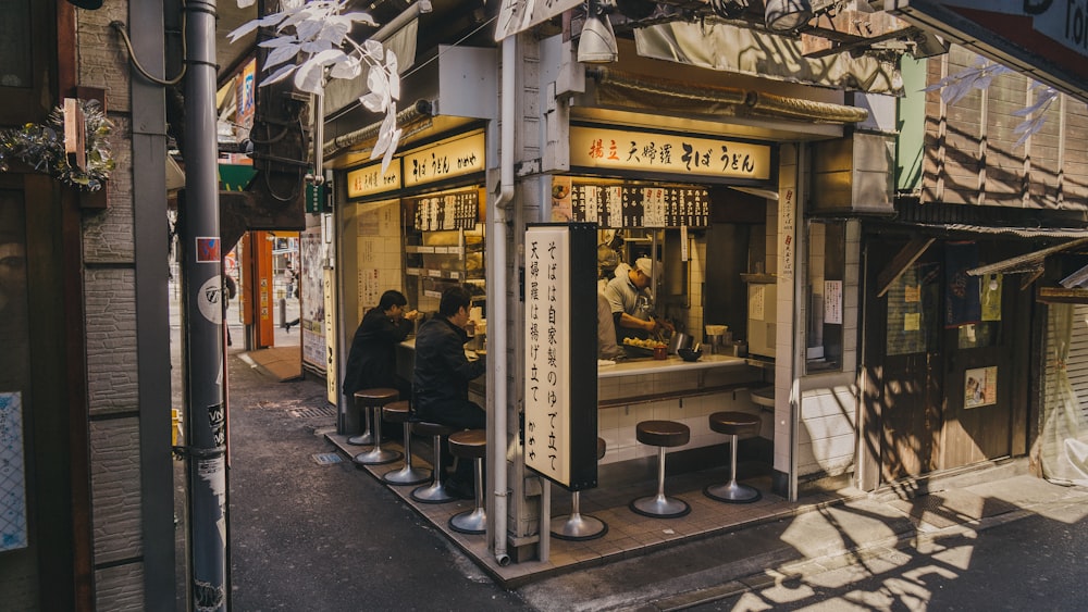 people eating inside stall beside street