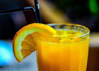 orange juice in drinking glass with slice orange fruit garnish