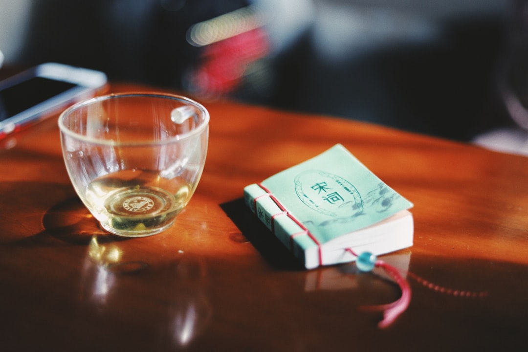 clear glass cup near sticky note on table