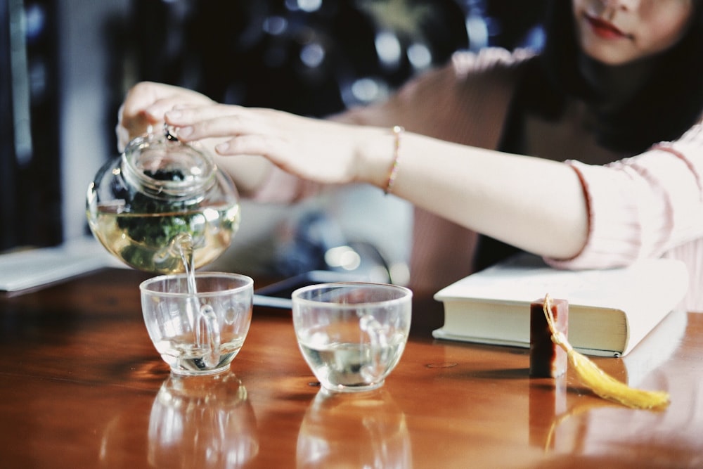 woman pouring tea on cups