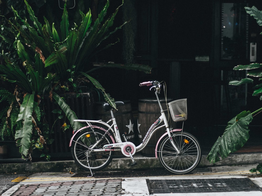 white step through bike parked near the plants