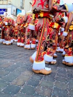 Students participating in a traditional Belgian festival, dressed in colorful costumes.
