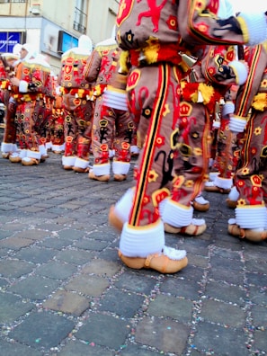 Students participating in a traditional Belgian festival, dressed in colorful costumes.