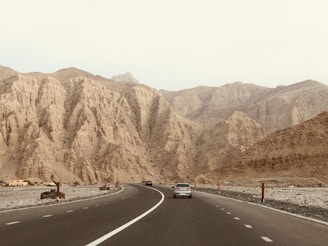 two vehicles on concrete highways near on mountains