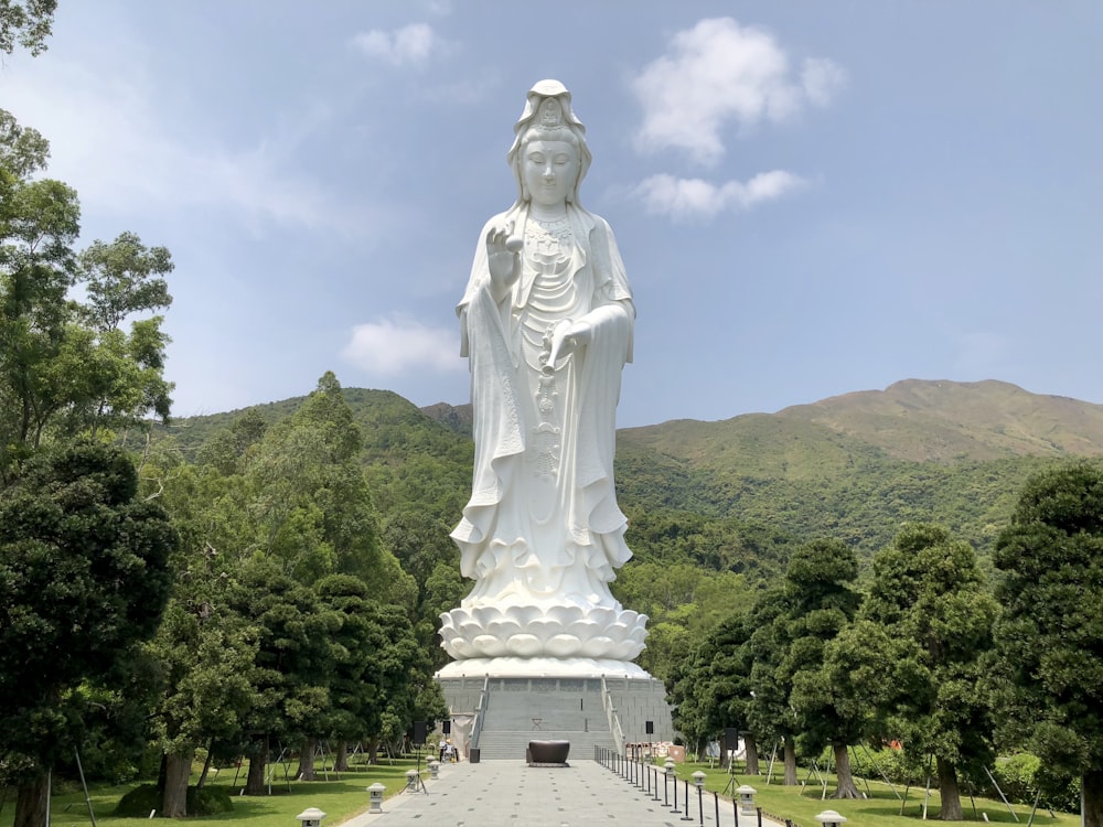 estátua de concreto da mulher ao lado das montanhas