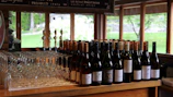The elegant bar counter at Ampelos lined with a colorful selection of Greek wines ready to be served.