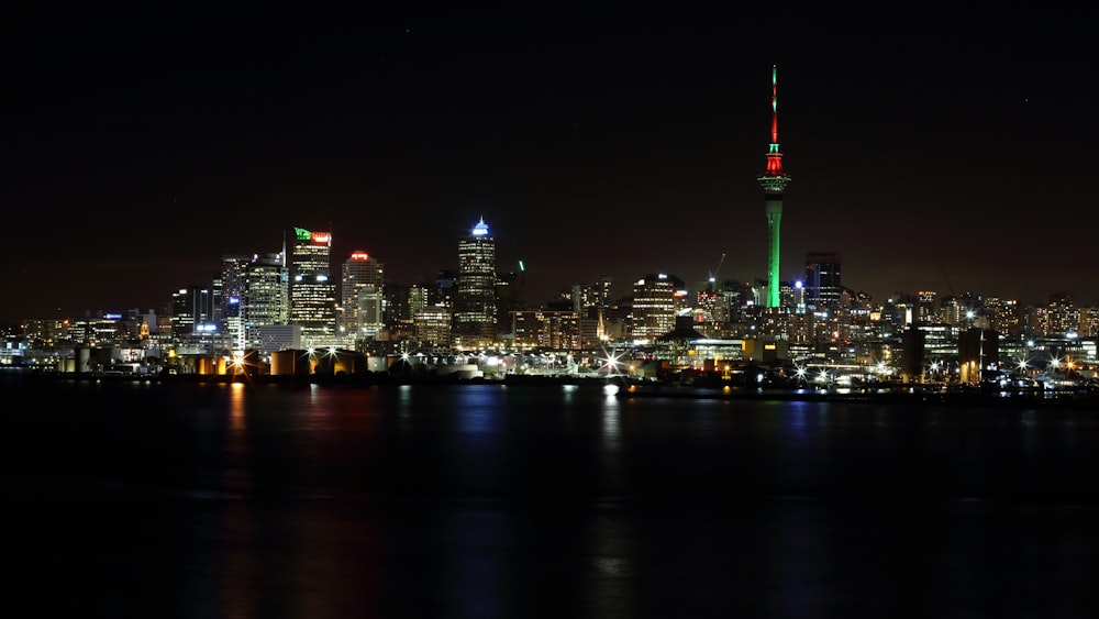 body of water near lighted high rise buildings during nighttime