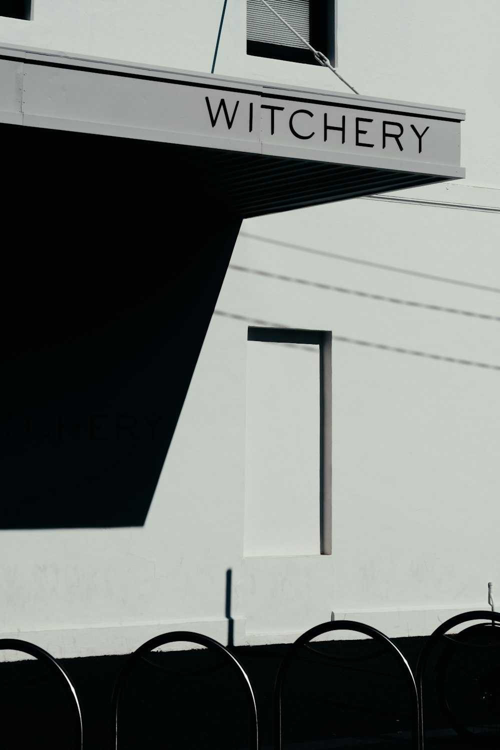 grayscale photography of Witchery signage