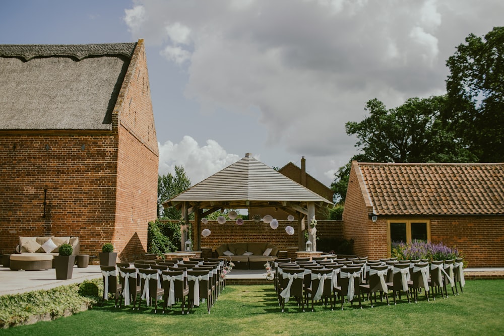 brown chair lot arranged in front of gazebo and house