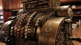 An old-fashioned cash register on a wooden counter.