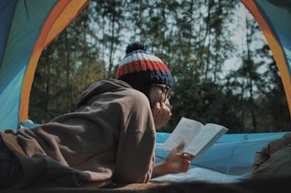 woman reading book in tent