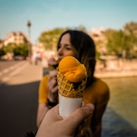 shallow focus photography of person holding ice cream in cone