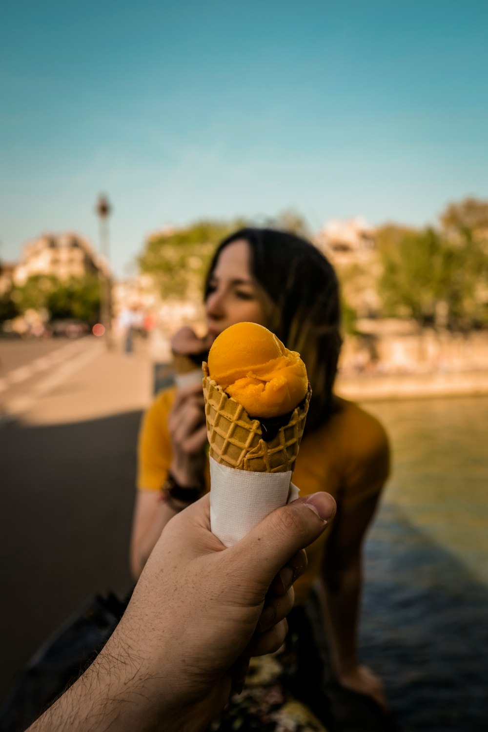 Photographie à mise au point peu profonde d’une personne tenant de la crème glacée dans un cône