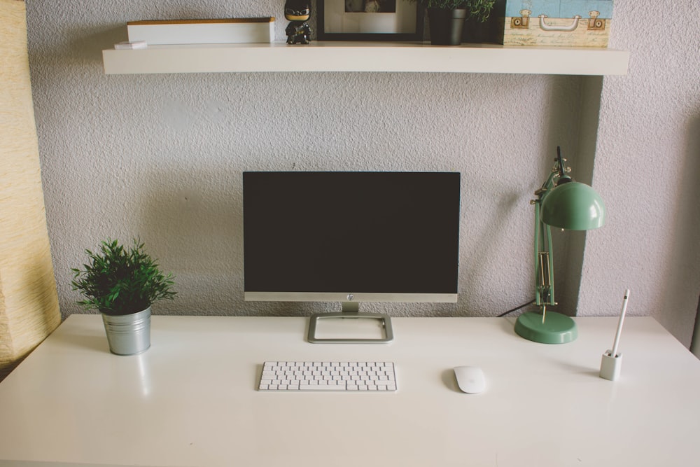 iMac argenté avec clavier et souris Apple Magic sur table blanche