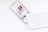 white iPhone under white Apple Magic Keyboard