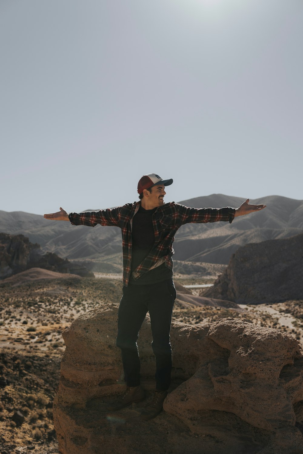 man wide arms open with mountain background