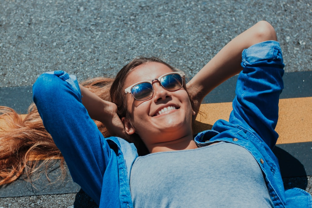 콘크리트 포장 도로에 누워있는 웃는 여자