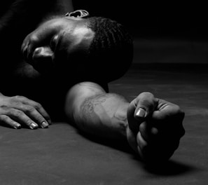 a man laying on the ground with his hands on his knees