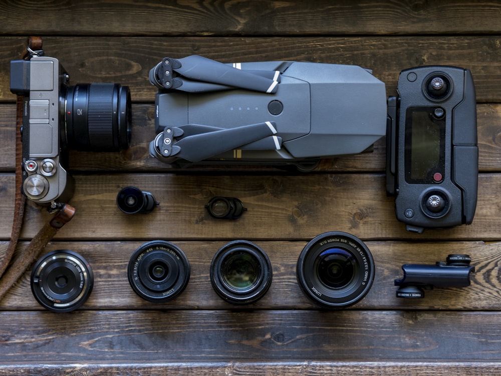 black and grey streaming drone and DSLR camera on brown wooden tabletop