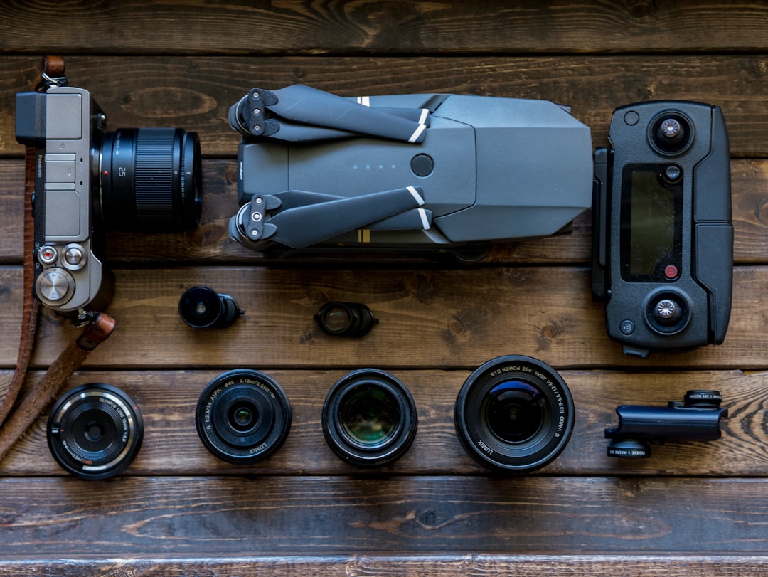 black and grey streaming drone and DSLR camera on brown wooden tabletop