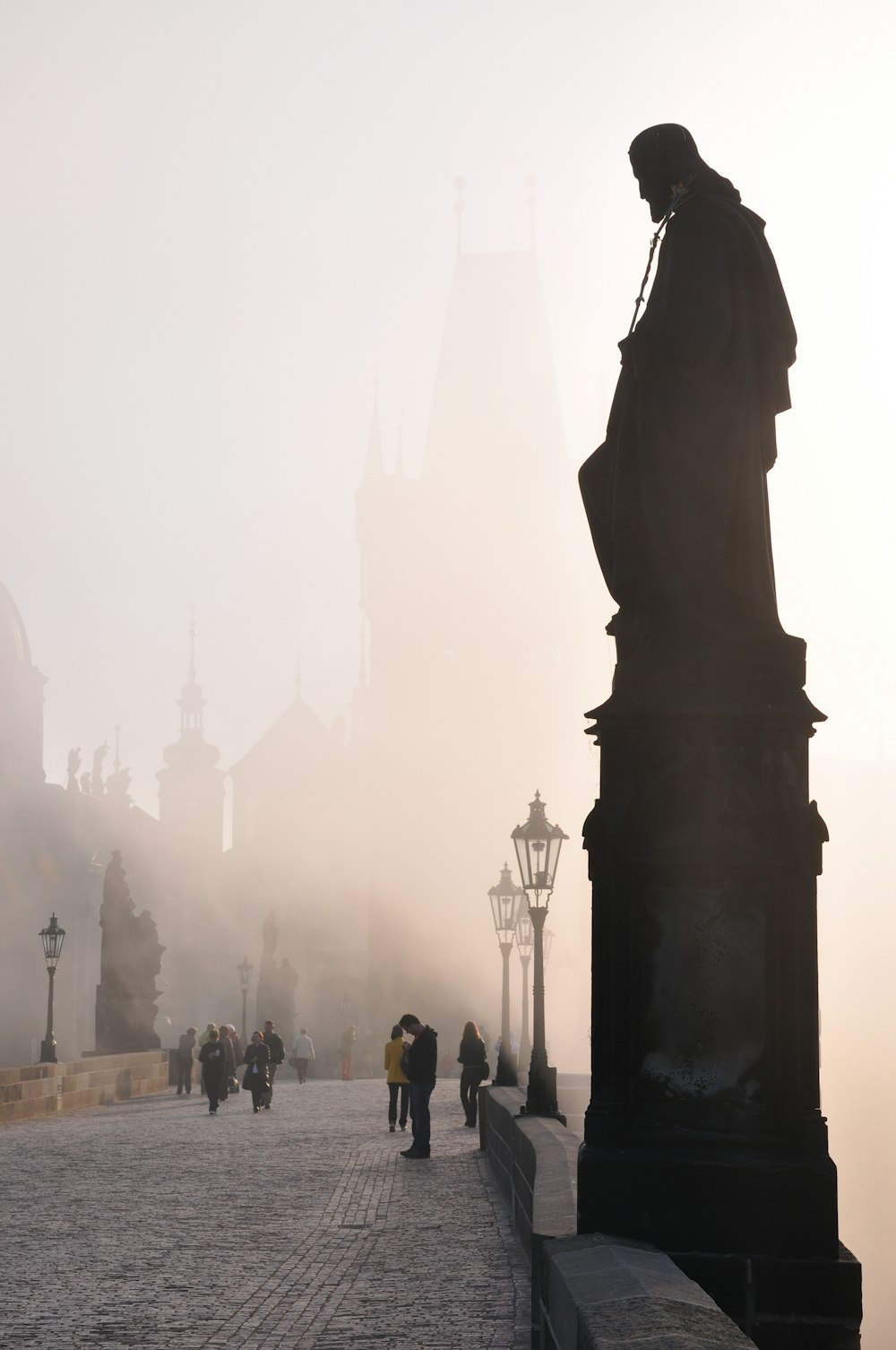 people standing near silhouette of statue