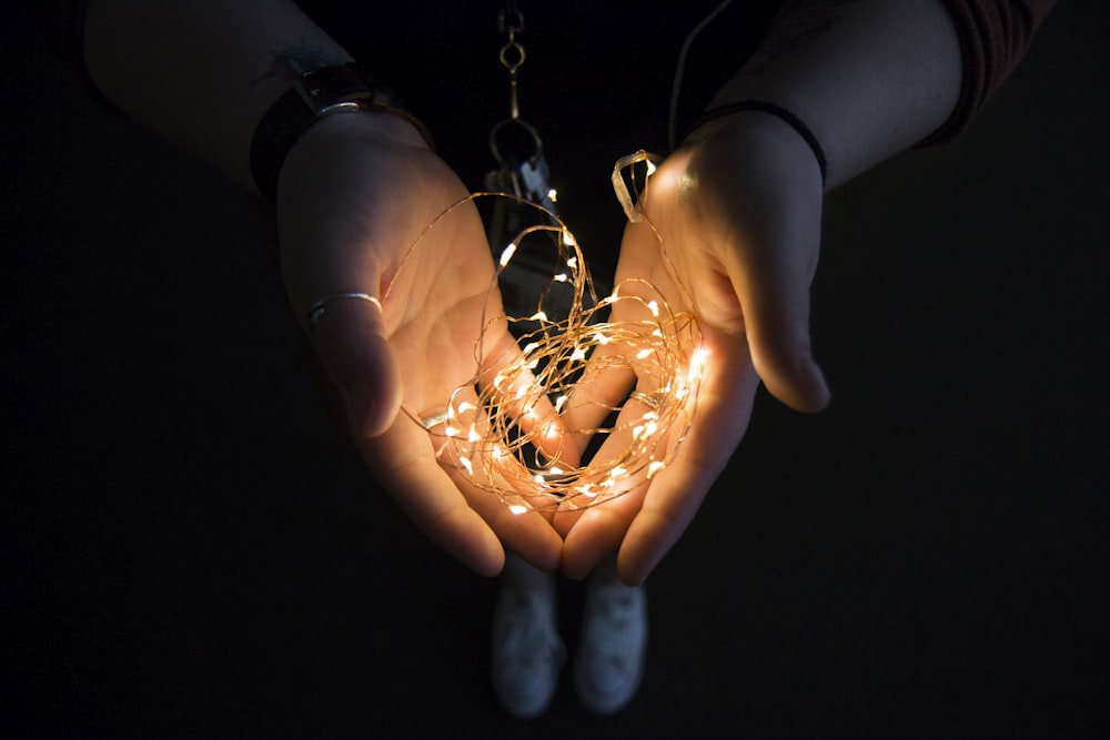 Cadena de luz amarilla en la mano humana