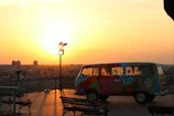 A panoramic view of a van overlooking a vast canyon at golden hour