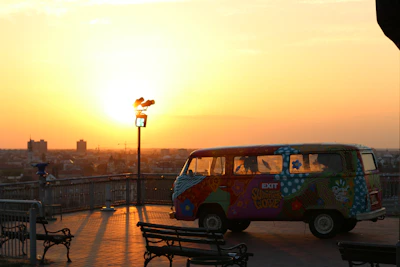 A panoramic view of a van overlooking a vast canyon at golden hour