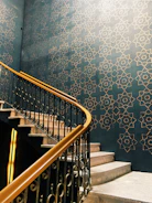 A professional painter carefully applying gold trim paint on a stylish modern staircase.