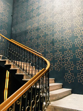 A professional painter carefully applying gold trim paint on a stylish modern staircase.