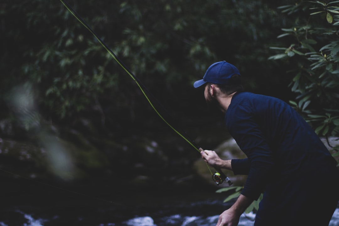 shallow focus photography of man fishing on River