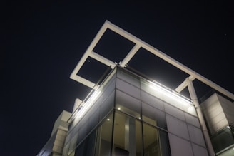 Modern commercial building illuminated by sleek LED fixtures at night.