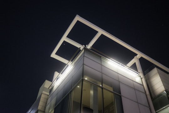 Modern commercial building illuminated by sleek LED fixtures at night.