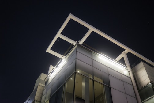 A sleek, modern commercial building at dusk with illuminated exterior lighting showcasing electrical design.
