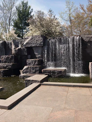 A soothing water feature surrounded by smooth stones and plants.