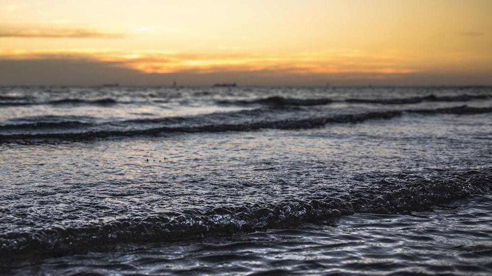 vague de mer sous le coucher du soleil