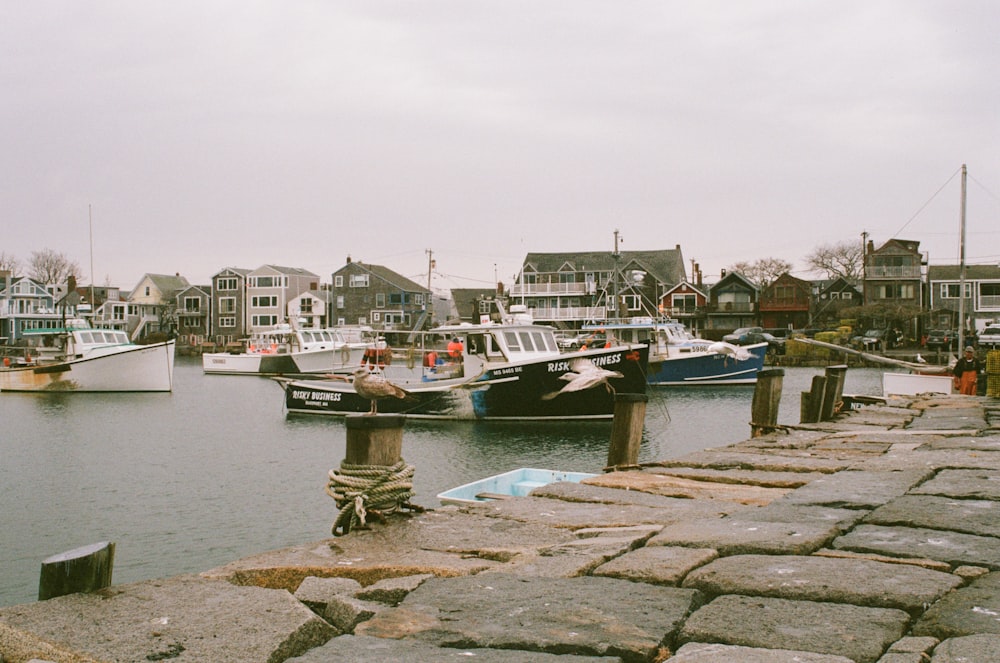 concrete brick floor near sea with boats under grey sky