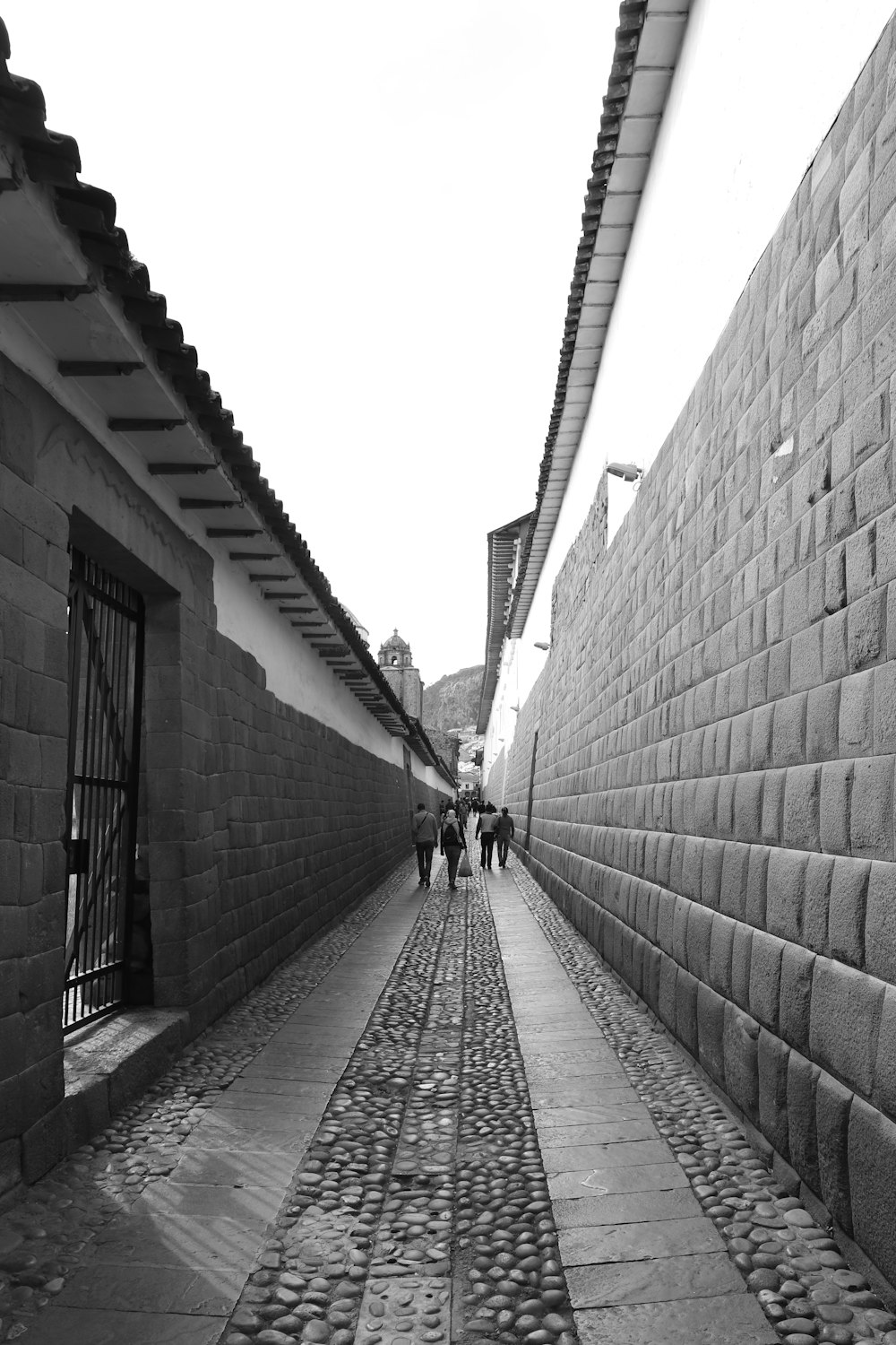 people walks near concrete wall