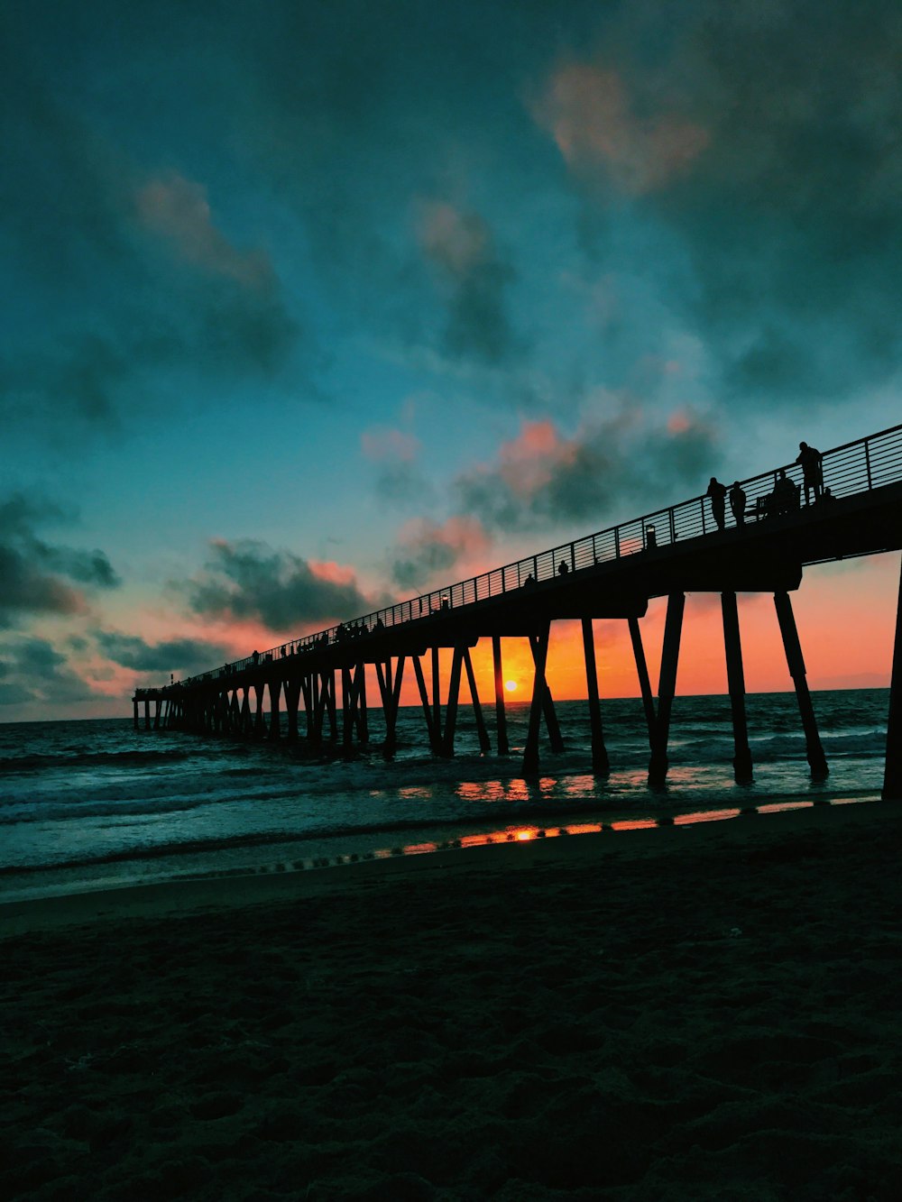 silhouette of people standing on bridge