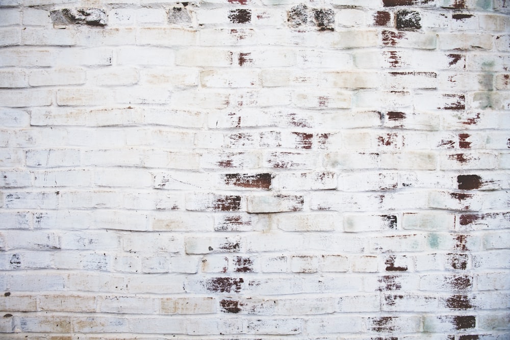 a white brick wall with a red fire hydrant in front of it