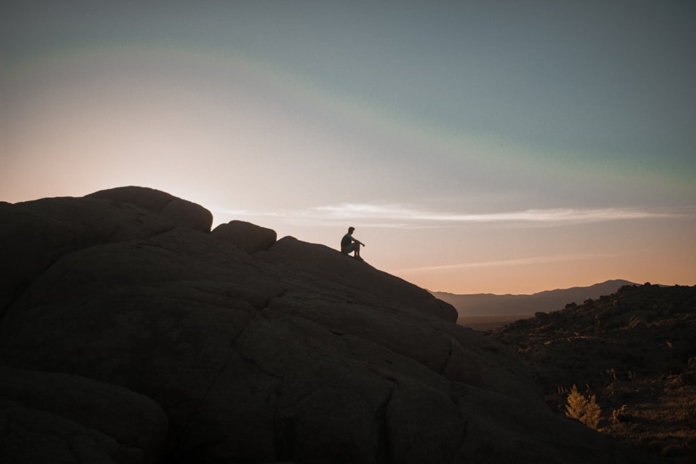 person sitting on rock