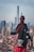 black haired woman in black coat staring at building during daytime