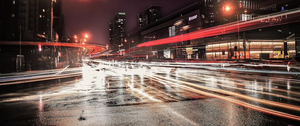 asphalt road with lights beside high-rise buildings during nighttime