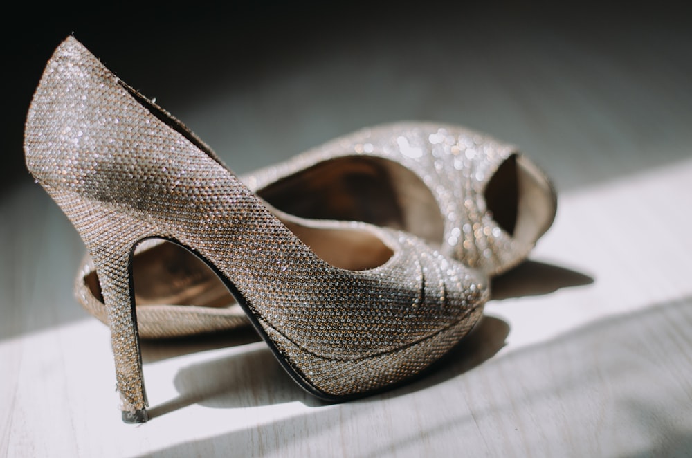 close up photography of pair of silver leather platform stilettos