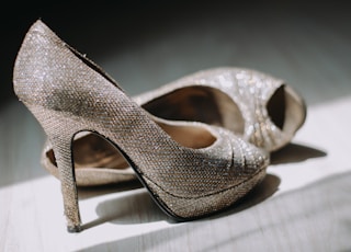 close up photography of pair of silver leather platform stilettos