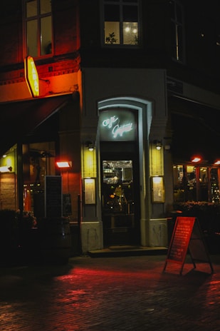 Dimly lit entrance of a cozy speakeasy with a vintage coffee shop facade.