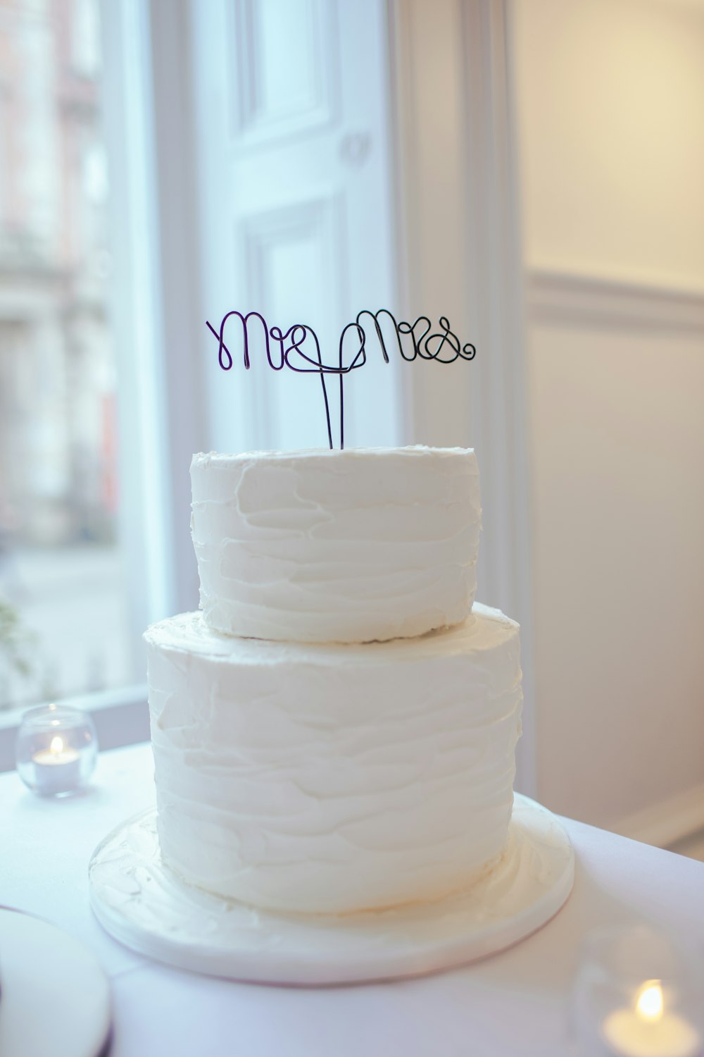 white 2-tier cake on white wooden table